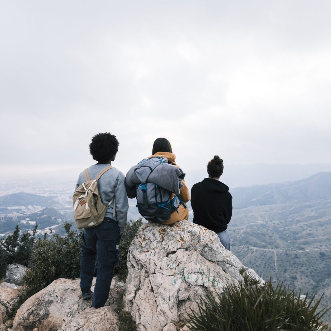 three-friends-mountain-top-looking-view